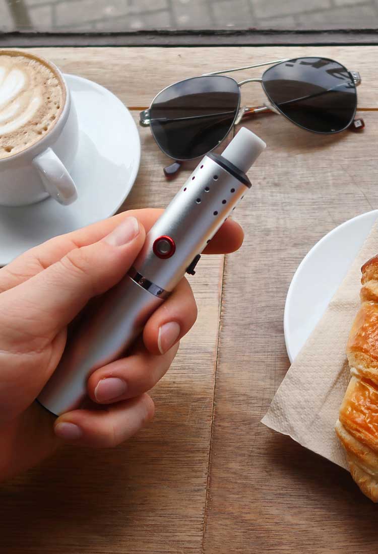 Vaping with a dry herb vaporizer in a cafe (mobile image)